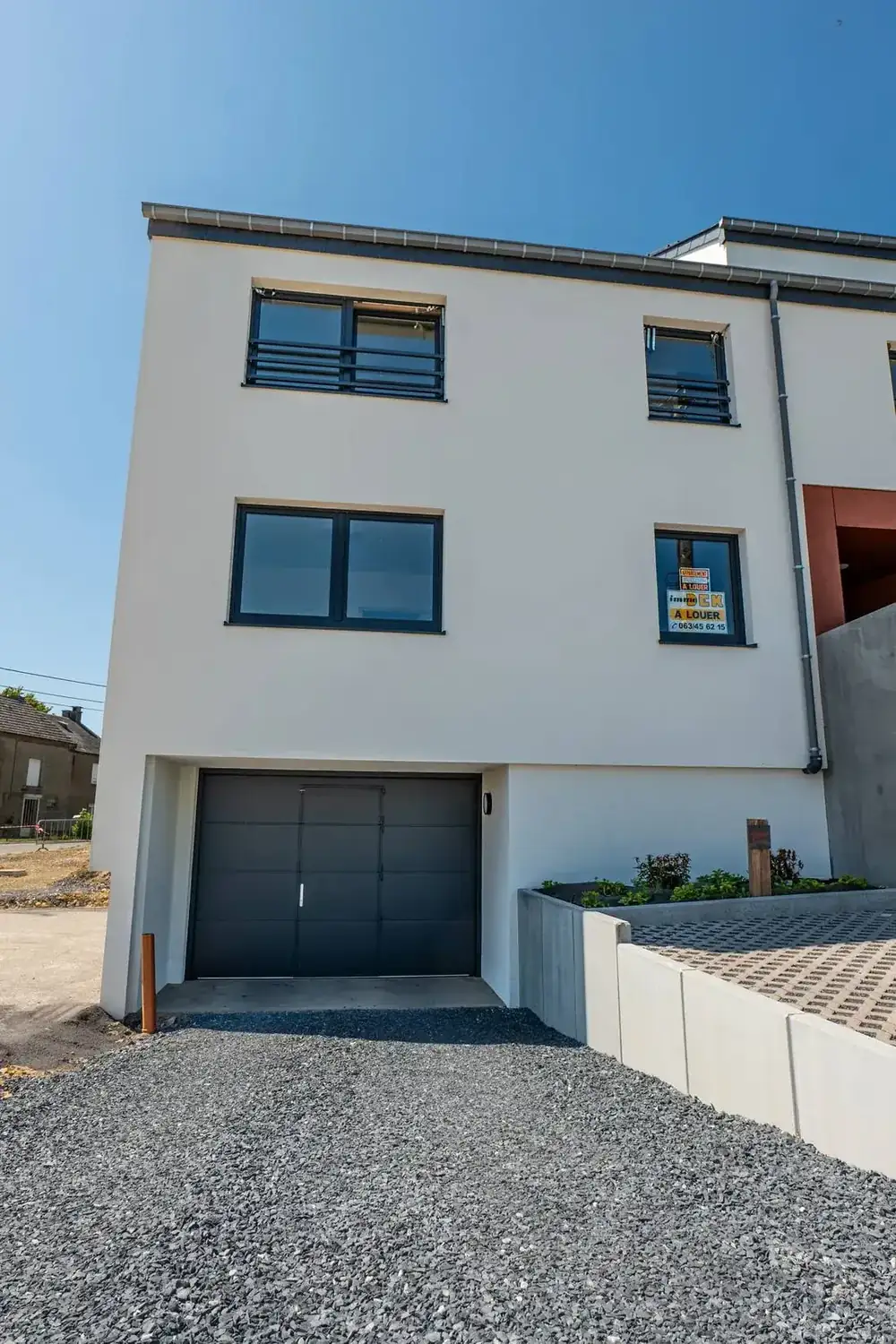 Appartements à Étalle — façade pignon et porte de garage