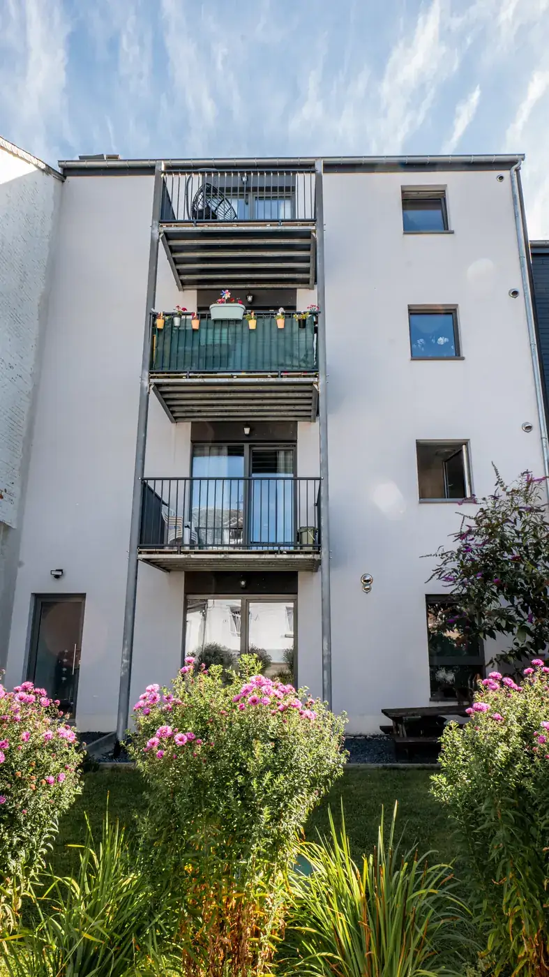 Appartements à Bertrix — jardin et façade arrière fleurie