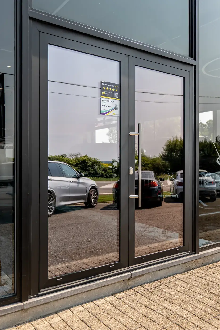 Garage WM à Bouillon — porte d'entrée vitrée du showroom