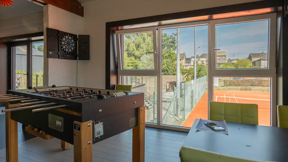 Tennis Club Bertrix — espace détente intérieur avec grandes baies vitrées